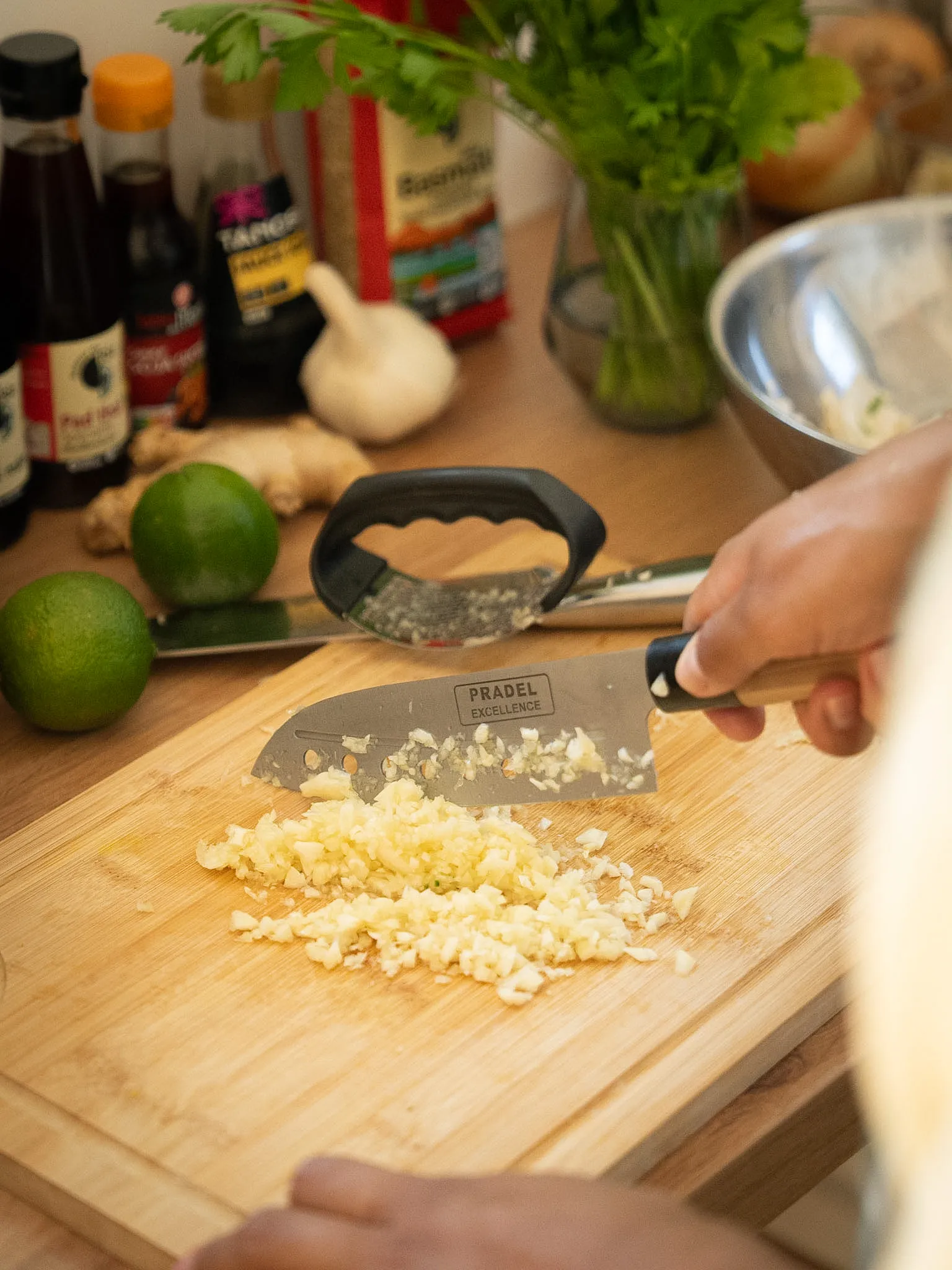 Ail émincé et mise en place : citron vert, gingembre et sauces prêts à l'emploi.